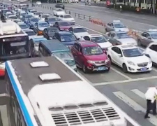 Пожилой китаец не успел перейти через автотрассу. Полицейский перенес его на себе (ВИДЕО)