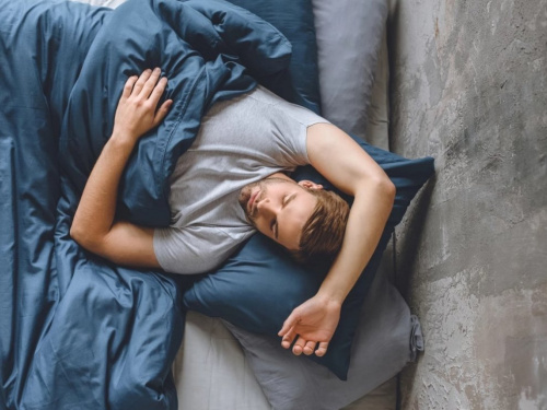 Чоловік спить у ліжку, синя постільна білизна - фото з відкритих джерел