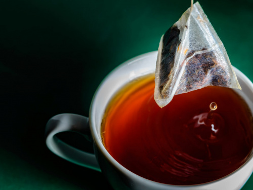 Чайний пакетик над чашкою чорного чаю - фото з відкритих джерел